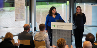 Mona Motakef und Katharina Hoppe hinter dem Rednerpult vor dem klatschenden Publikum