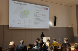 Foto: Vortrag in einem Konferenzraum mit Präsentation zu einem Projekt über regionale Entwicklung vor Publikum.