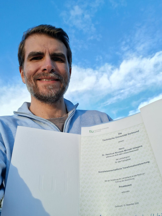 Rick Hölsgens hält seine Urkunde in die Kamera.