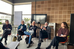 Foto: 5 Personen sitzen vor einem Publikum bei einer Panel-Diskussion