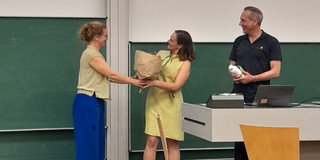 Frau Prof. Dr. Martina Brandt heißt Frau Prof. Dr. Anita Tisch mit einem Blumenstrauß willkommen.