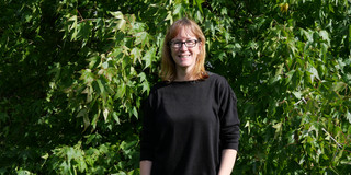 Employee Yvonne Zech is standing in front of a tree