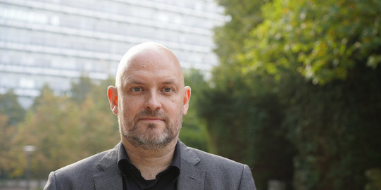 The photo shows a portrait of Dr. Christian Deindl.