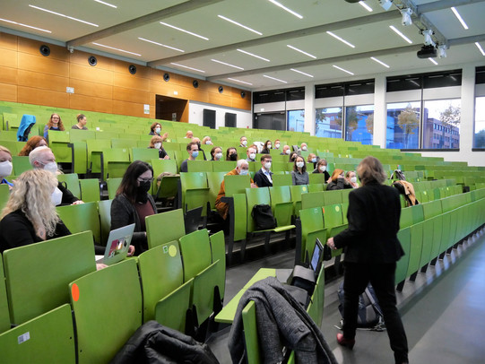 The photo shows the audience at the inaugural lecture of Prof. Mona Motakef. They sit in the lecture hall with distance and mouth-nose protection.