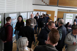Fakultätsforschungstag 2024_Austausch bei der Postersession Auf dem Foto sind Teilnehmende des Fakultätsforschungstages abgegebildet, die sich angeregt über die Poster austauschen.