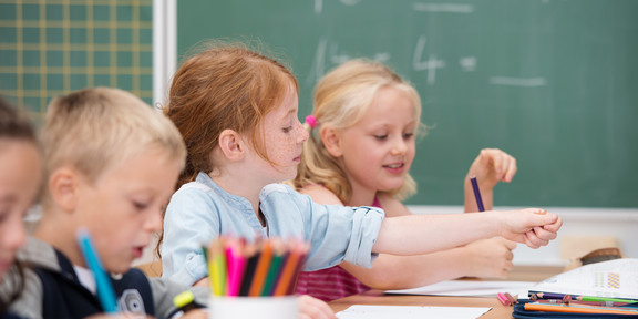 Mehrere Kinder sitzen in einer Schulklasse.