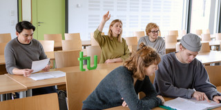 Studierende im Seminarraum sitzen am Tisch
