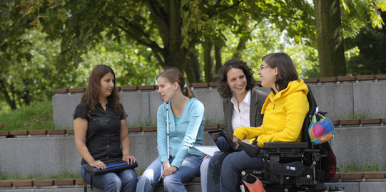 Students with handicap are sitting together on campus.