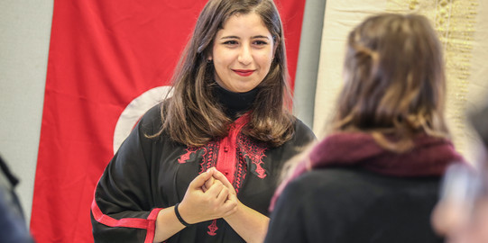 Eine internationale Studierende in traditioneller Kleidung im Gespräch mit einer Kommilitonin am International Day an der TU Dortmund
