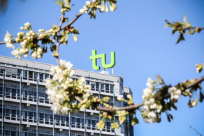 The picture shows the Mathetower and cherry blossoms in the foreground.